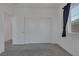Bright bedroom featuring carpet floors, large windows, and convenient closet space at 5589 Pico Ferrera Ct, Las Vegas, NV 89113