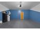 Spacious garage with blue accent wall, equipped with epoxy flooring and storage options at 5589 Pico Ferrera Ct, Las Vegas, NV 89113