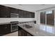 Granite countertops, stainless appliances, and dark cabinets in a modern kitchen design at 5589 Pico Ferrera Ct, Las Vegas, NV 89113