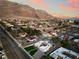 Stunning aerial view of the community with mountain backdrop, lush greenery, and city lights in the distance at 6861 E Washington Ave, Las Vegas, NV 89110