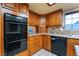 Open kitchen featuring built-in ovens, granite countertops, and ample wood cabinets at 6861 E Washington Ave, Las Vegas, NV 89110