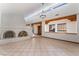 Spacious living room featuring a unique fireplace, tile flooring, and exposed wood beams at 6861 E Washington Ave, Las Vegas, NV 89110