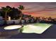 Resort-style pool and spa area featuring lush tropical landscaping and mountain views at sunset at 6861 E Washington Ave, Las Vegas, NV 89110