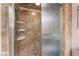 Tiled shower featuring a rain shower head, built in soap dishes and frosted glass door at 6861 E Washington Ave, Las Vegas, NV 89110