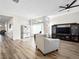 Bright and airy living room with hardwood floors, a ceiling fan, and a large window at 8276 Aurora Peak Ave, Las Vegas, NV 89131