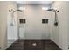 Modern walk-in shower featuring dual shower heads, gray tile, and black hexagon tile floor at 8276 Aurora Peak Ave, Las Vegas, NV 89131