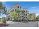 Beautiful multi-story condo building featuring a stucco exterior, and a well-manicured landscaped entrance at 9213 Las Manaitas Ave # 401, Las Vegas, NV 89144