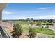 Beautiful golf course view from balcony with golf carts and players on the green under a vast blue sky at 9213 Las Manaitas Ave # 401, Las Vegas, NV 89144