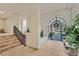 Elegant condo hallway with tiled floors, staircase, and a decorative wrought iron gate to the outside at 9213 Las Manaitas Ave # 401, Las Vegas, NV 89144