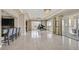Spacious living room boasting tile flooring, sliders to balcony, modern lighting, and a bar area at 9213 Las Manaitas Ave # 401, Las Vegas, NV 89144