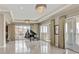 Open concept living room featuring tile flooring, floor to ceiling sliding glass doors, and a piano at 9213 Las Manaitas Ave # 401, Las Vegas, NV 89144
