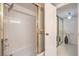 Bathroom featuring a shower with glass doors and adjacent hallway with mirrored doors at 205 E Harmon Ave # 803, Las Vegas, NV 89169