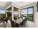 Bright dining room featuring a long wood table, chandelier, and glass doors leading to outdoor pool at 387 Solitude Peak Ln, Henderson, NV 89012