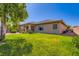 Home exterior with grass lawn, covered patio, neutral paint, and professional landscaping at 3908 Specula Wing Dr, North Las Vegas, NV 89084