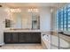 Well-lit bathroom with double sinks, bathtub, and stylish cabinets and fixtures at 3908 Specula Wing Dr, North Las Vegas, NV 89084