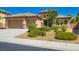 Charming single-story home showcasing a three-car garage, desert landscaping, and a tile roof at 3908 Specula Wing Dr, North Las Vegas, NV 89084