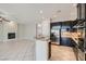 Open concept kitchen and living room with stainless steel appliances and tile floors at 3908 Specula Wing Dr, North Las Vegas, NV 89084