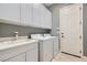 Functional laundry room with washer, dryer, sink, and ample cabinet space for storage at 3908 Specula Wing Dr, North Las Vegas, NV 89084