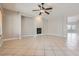 Open living room with tile flooring, fireplace, ceiling fan, and neutral paint, creating an inviting atmosphere at 3908 Specula Wing Dr, North Las Vegas, NV 89084