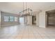 Spacious living room with tile flooring, modern chandelier, neutral paint, and ample natural light from the windows at 3908 Specula Wing Dr, North Las Vegas, NV 89084