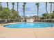 Community pool surrounded by lush landscaping and tall palm trees at 3908 Specula Wing Dr, North Las Vegas, NV 89084