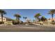 Courts at Aliante street view features palm trees and lush landscaping in the foreground at 3908 Specula Wing Dr, North Las Vegas, NV 89084