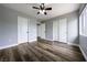 Neutral bedroom features wood floors, a ceiling fan, and closet for storage at 6045 Riverwalk Falls St # 102, North Las Vegas, NV 89031