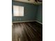 Bedroom featuring stylish flooring, blue walls, and window at 6045 Riverwalk Falls St # 102, North Las Vegas, NV 89031
