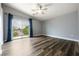 Spacious bedroom with hardwood floors and sliding door with blue curtains at 6045 Riverwalk Falls St # 102, North Las Vegas, NV 89031