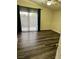 Bright bedroom with dark wood-look flooring, a ceiling fan, and natural light from a large window at 6045 Riverwalk Falls St # 102, North Las Vegas, NV 89031