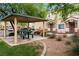 A peaceful gazebo with picnic table nestled in a grassy area beside well-maintained condominium buildings at 6045 Riverwalk Falls St # 102, North Las Vegas, NV 89031