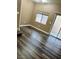 Welcoming living room with dark wood-look flooring, a sliding glass door, and a window at 6045 Riverwalk Falls St # 102, North Las Vegas, NV 89031