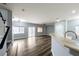 Open concept living room with hardwood floors, adjacent to kitchen counter seating at 6045 Riverwalk Falls St # 102, North Las Vegas, NV 89031