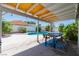Outdoor dining area with a covered patio overlooking a pool and landscaped backyard at 6361 W Viking Rd, Las Vegas, NV 89103