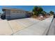 Single-story home featuring a two-car garage, mature trees and landscaping at 6361 W Viking Rd, Las Vegas, NV 89103