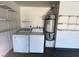 Washer, dryer, and water heater featured with shelving in this home's garage at 6361 W Viking Rd, Las Vegas, NV 89103