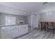 Open concept kitchen with grey wood flooring, island, dining table, and view to a fireplace at 6361 W Viking Rd, Las Vegas, NV 89103
