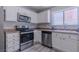 Modern kitchen with stainless steel appliances, white cabinetry, and sleek countertops at 6361 W Viking Rd, Las Vegas, NV 89103