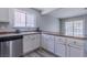 Bright kitchen featuring white cabinets, stainless steel dishwasher and sink, and laminate countertops at 6361 W Viking Rd, Las Vegas, NV 89103