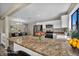 Modern kitchen with a granite countertop island, stainless appliances, and adjacent dining area for seamless entertaining at 6361 W Viking Rd, Las Vegas, NV 89103