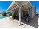 Covered outdoor patio featuring a grill and dining area with a view of the backyard swimming pool at 6361 W Viking Rd, Las Vegas, NV 89103