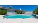 A backyard pool surrounded by lush landscaping and a covered patio area perfect for outdoor relaxation and entertaining at 6361 W Viking Rd, Las Vegas, NV 89103