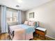 Bedroom featuring a bed, wood floors, curtains, and a side table near the window at 8701 Giant Causeway Ave, Las Vegas, NV 89148