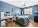 Bedroom featuring a bed, a vanity, a desk, wood floors, and large window at 8701 Giant Causeway Ave, Las Vegas, NV 89148