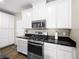 This well-equipped kitchen features white cabinetry, stainless steel appliances, and dark countertops at 8701 Giant Causeway Ave, Las Vegas, NV 89148