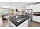 An open-concept kitchen displays an island with stainless steel appliances and sink with seating around the island at 8701 Giant Causeway Ave, Las Vegas, NV 89148