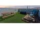 Relaxing rooftop deck with chairs, picnic table, synthetic grass, and scenic mountain views for entertaining and outdoor enjoyment at 8701 Giant Causeway Ave, Las Vegas, NV 89148