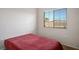 Bedroom with neutral walls, carpet, a window with blinds and red bedding at 9303 Gilcrease Ave # 2178, Las Vegas, NV 89149