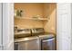 A laundry room with a new washer and dryer, a wire shelf, and a closed white door at 9303 Gilcrease Ave # 2178, Las Vegas, NV 89149