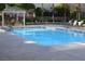 Sparkling community pool with sun loungers and a pergola-covered seating area at 9303 Gilcrease Ave # 2178, Las Vegas, NV 89149